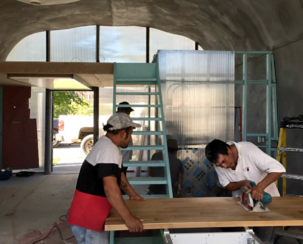 men working inside of quonset hut