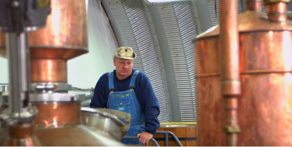 Distillery equipment and a member of Dave Reavis' crew inside the metal structure.