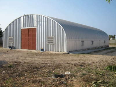 S-Model Quonset hut with red garage door, side view